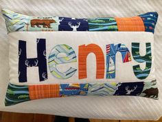 a pillow that has the word henry on it and some animals in different colors, shapes and sizes