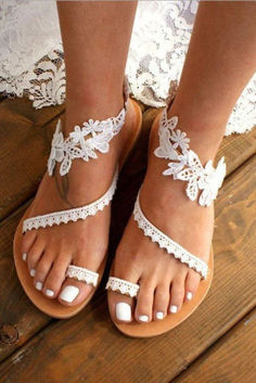 a close up of a person's feet wearing sandals with lace and beads on them