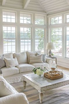 a living room filled with white furniture and lots of windows in it's walls