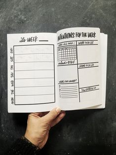 someone is holding up a planner for their week