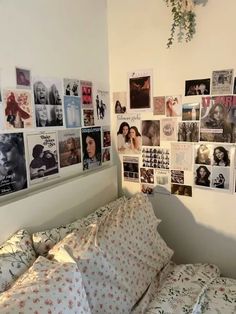 a bed with lots of pictures on the wall and pillows in front of it's headboard