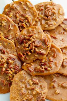 a white plate topped with cookies covered in pecans