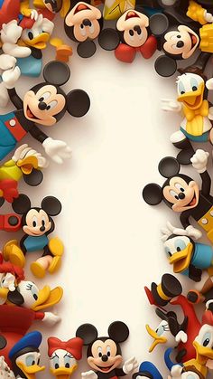 a group of mickey mouse figurines sitting on top of a white sheet with space in the middle