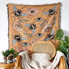 a chair with a blanket on top of it next to a table and potted plants