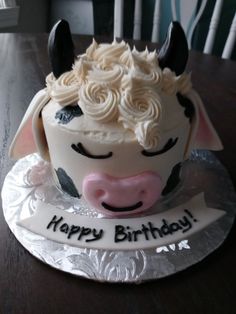 a birthday cake shaped like a cow on a table