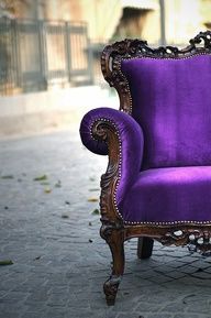 a purple chair sitting on top of a sidewalk