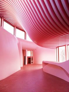 an empty room with pink walls and large windows