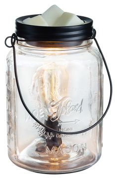 a glass jar with a candle inside on a white background