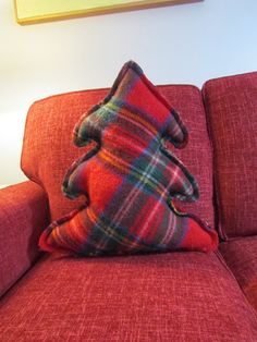 a red couch with a plaid pillow on it