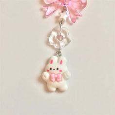 a keychain with a pink bow and white bunny on it's side