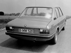 an old bmw is parked on the side of the road