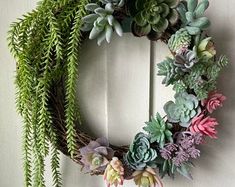 a wreath with succulents hanging on a door