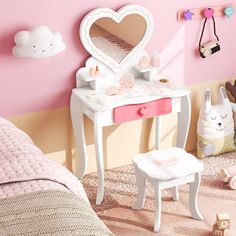 a bedroom with a pink wall and white furniture in the corner, including a vanity table