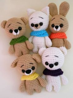 several crocheted teddy bears are arranged in a circle on a white surface with black eyes