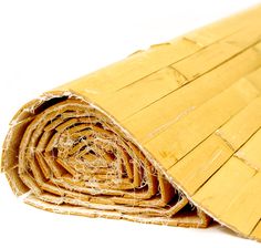 a rolled up bamboo mat on a white background