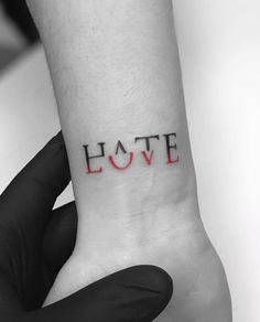 the word love is written in red ink on someone's left wrist and hand