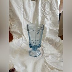 a clear glass sitting on top of a white sheet