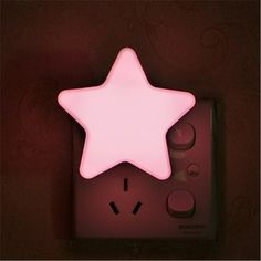 a pink star shaped light sitting on top of a remote control