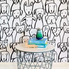 a table with two books on it in front of a wall with dogs drawn on it