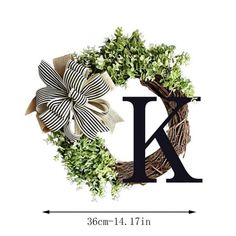 a wreath with the letter k on it and a bow hanging from it's side