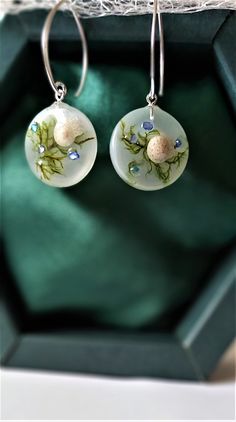 the earrings are decorated with flowers and leaves