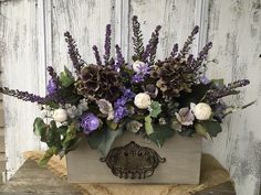 a wooden box filled with purple and white flowers