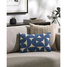 a blue and white pillow sitting on top of a couch next to a framed photograph