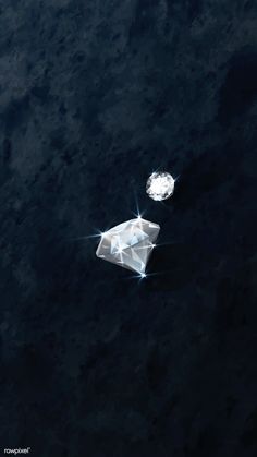 an aerial view of two diamonds floating in the dark water with one diamond on top