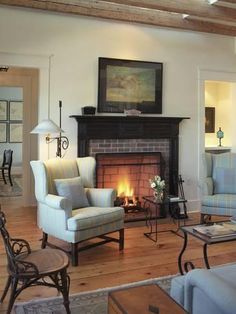 a living room filled with furniture and a fire place in the middle of a room