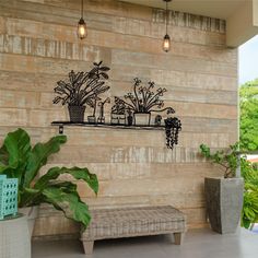 a wall with some plants on it and a bench in front of the planter