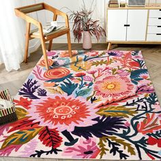 an area rug with flowers on it in a room next to a chair and table