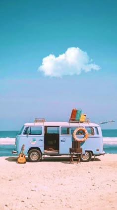 a vw bus parked on the beach with surfboards and life preserver attached to it