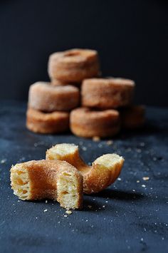 a pile of doughnuts sitting on top of a black table next to each other