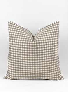 a brown and white checkered pillow on a white background