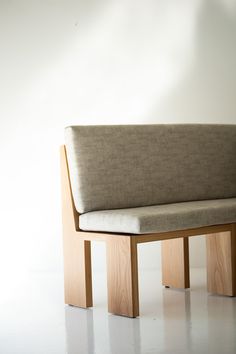 a wooden bench sitting on top of a white floor covered in light colored fabric and wood