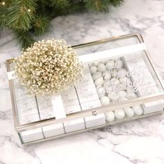 a christmas ornament sitting on top of a table next to a pine tree