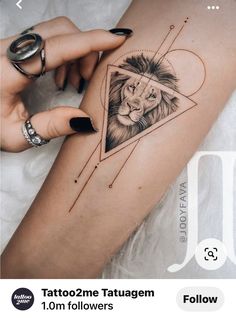 a woman's leg with a lion tattoo on it and an arrow in the shape of a heart