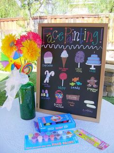 a chalkboard with pictures on it next to some candy and flowers in a vase