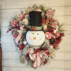 a christmas wreath with a snowman wearing a top hat