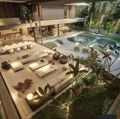 an aerial view of a living room and pool area at night with lights shining on the couches