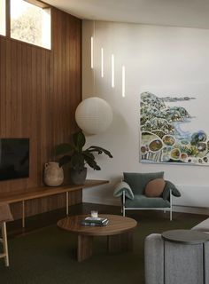 a living room filled with furniture and a painting on the wall