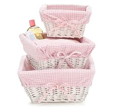 three wicker baskets stacked on top of each other with bottles in the bottom basket