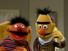 two sesame street characters standing next to each other