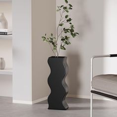 a black vase with a plant in it next to a white chair and shelves on the wall