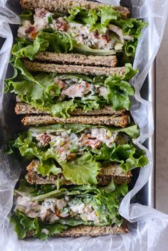 a tray filled with sandwiches covered in lettuce