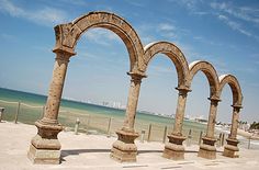 an arch in the sand near the ocean