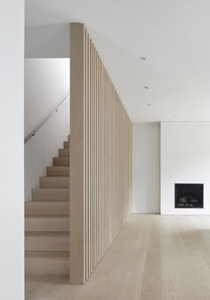 an empty living room with stairs leading up to the fire place