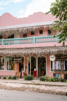 a pink building with thatched roof and balconies