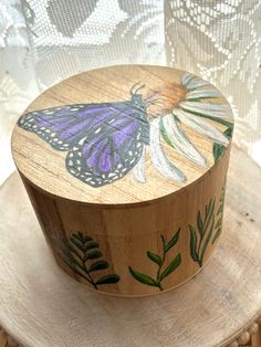 a wooden box with a butterfly painted on it