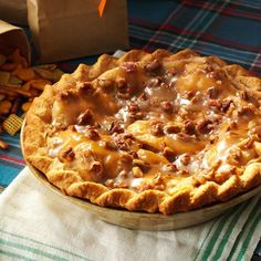 a pie sitting on top of a table next to crackers and a paper bag